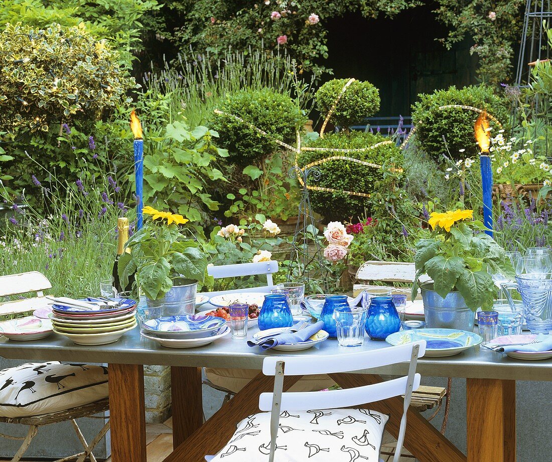 Gedeckter Tisch mit Früchten und Sonnenblumen im Freien