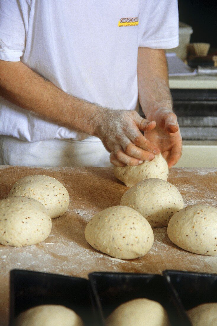Baker shaping bread rolls