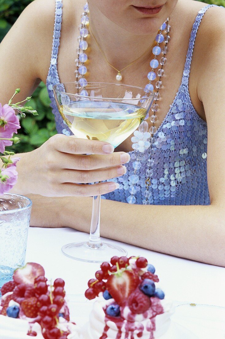 Junge Frau hält ein Glas Weißwein