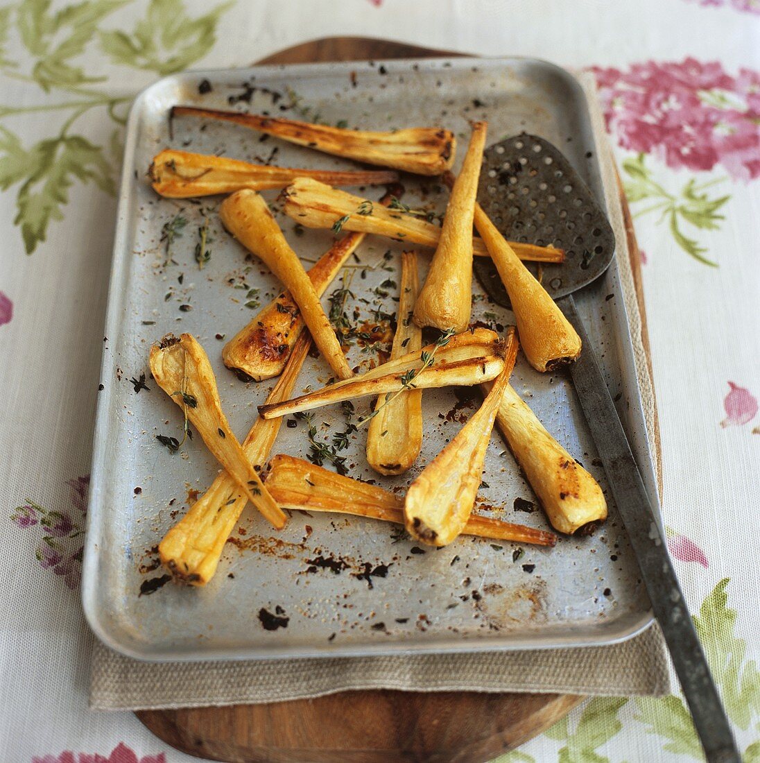 Roasted parsnips with thyme on a baking tray