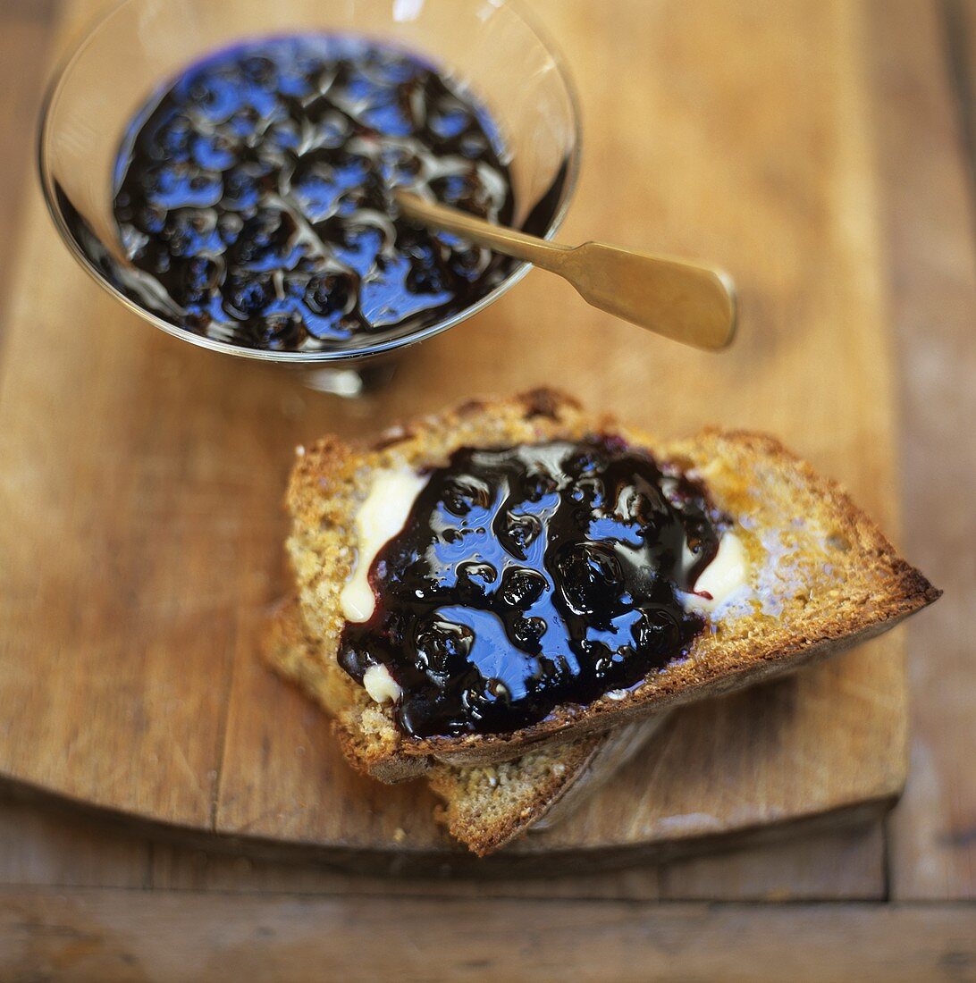 Blueberry jam on toasted bread and in small bowl
