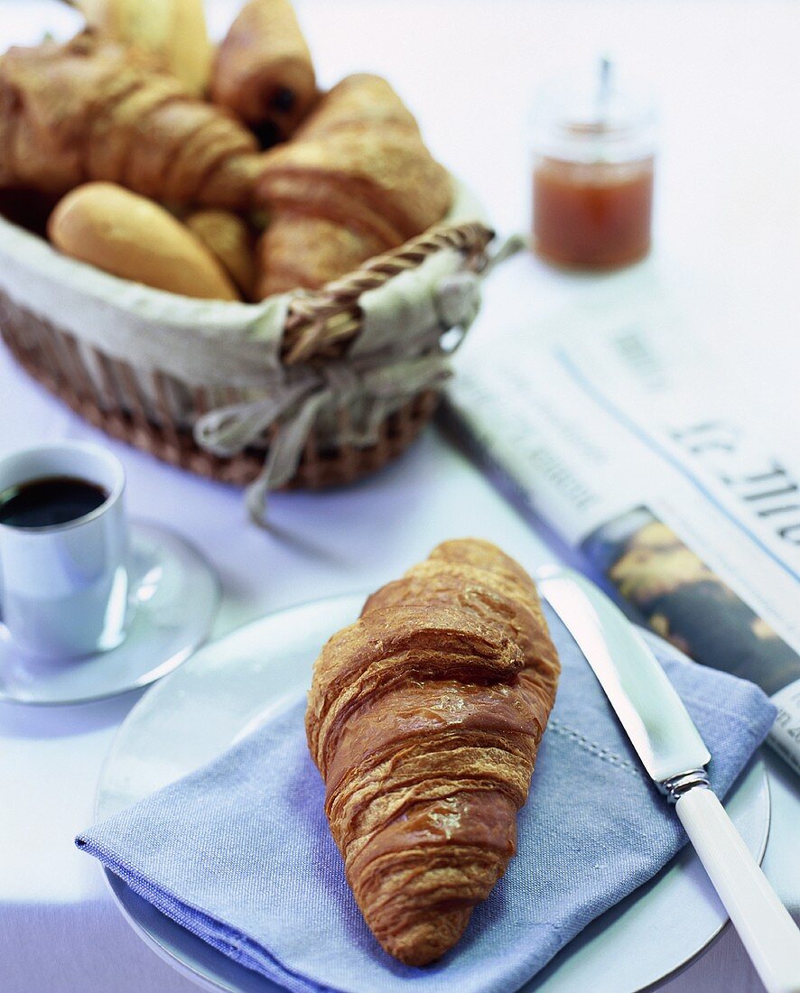 Breakfast: croissant, coffee and newspaper