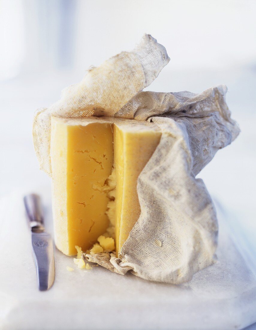 Ripe Cheddar cheese with muslin cloth