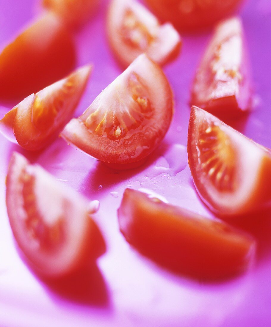 Tomato wedges on purple background