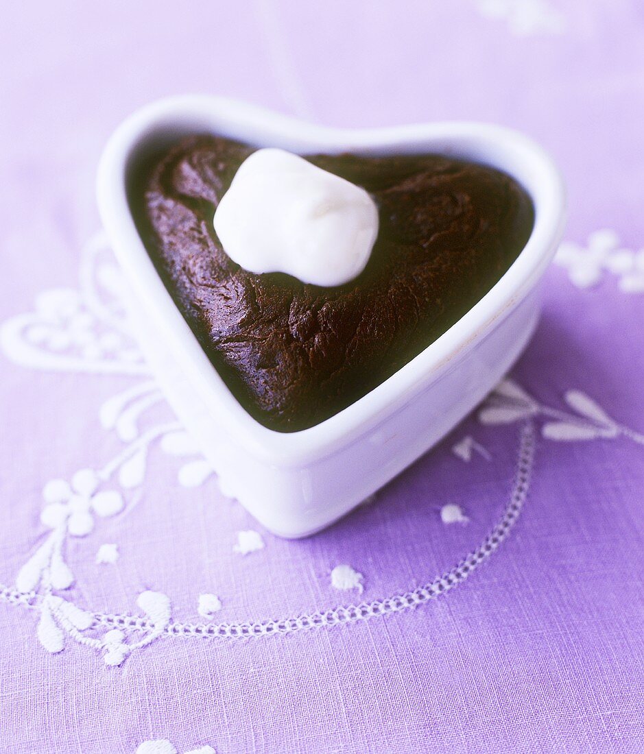 Chocolate pudding with cream in heart-shaped dish