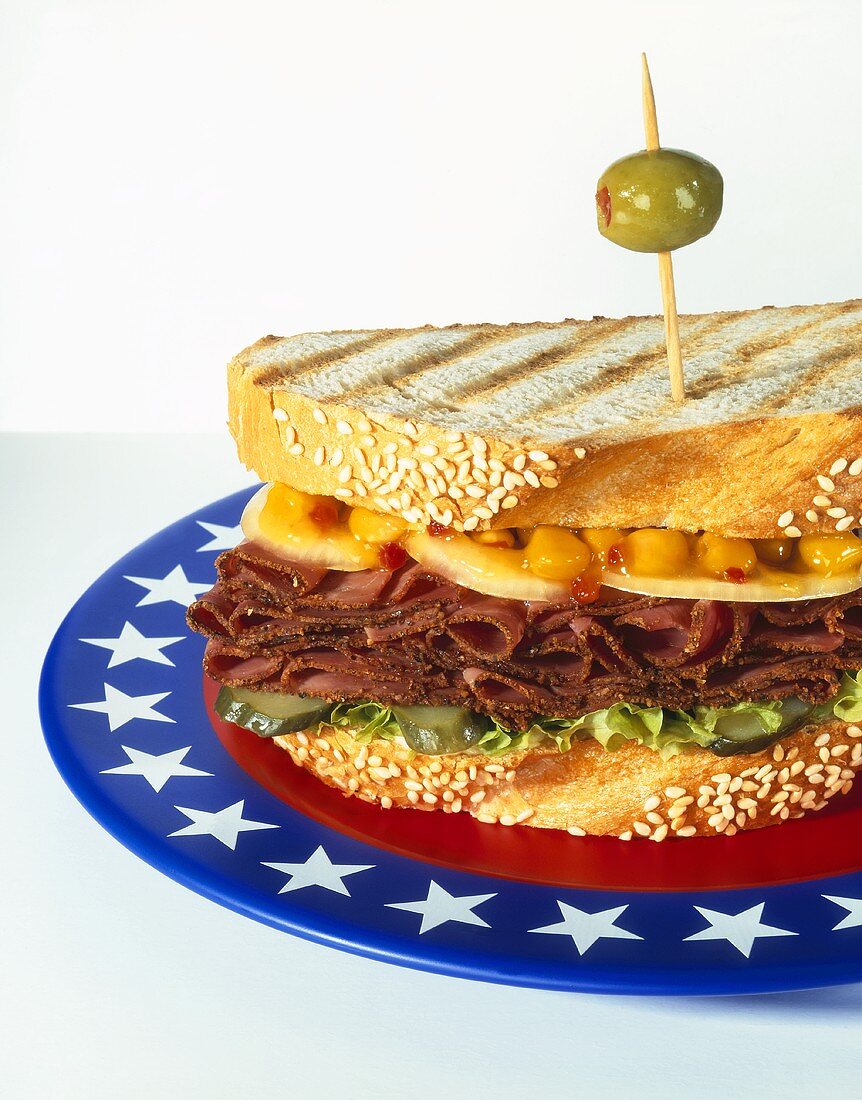 Pastrami sandwich in sesame toast on plate with US colours