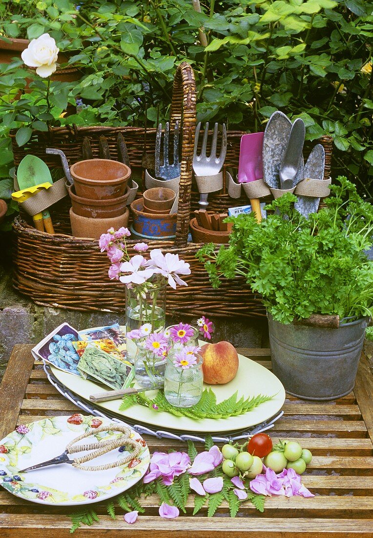 Ein Korb mit Gartenwerkzeug, Blumen und Kräuter