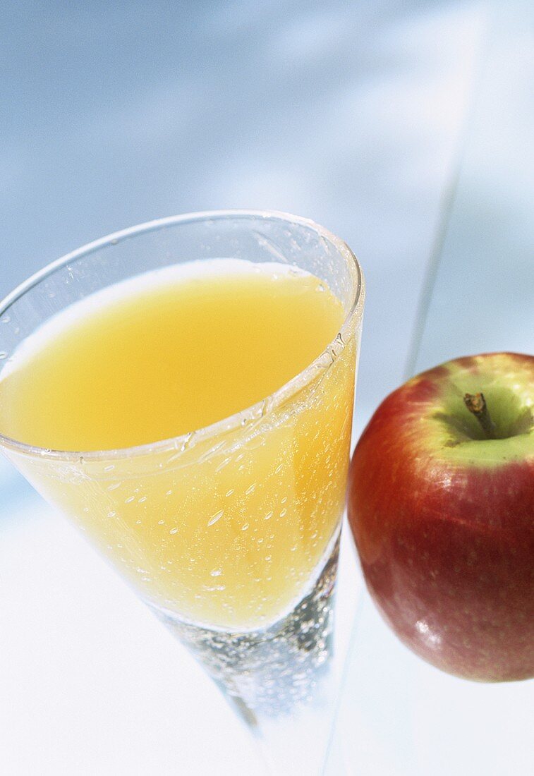 Glass of apple juice and a fresh apple