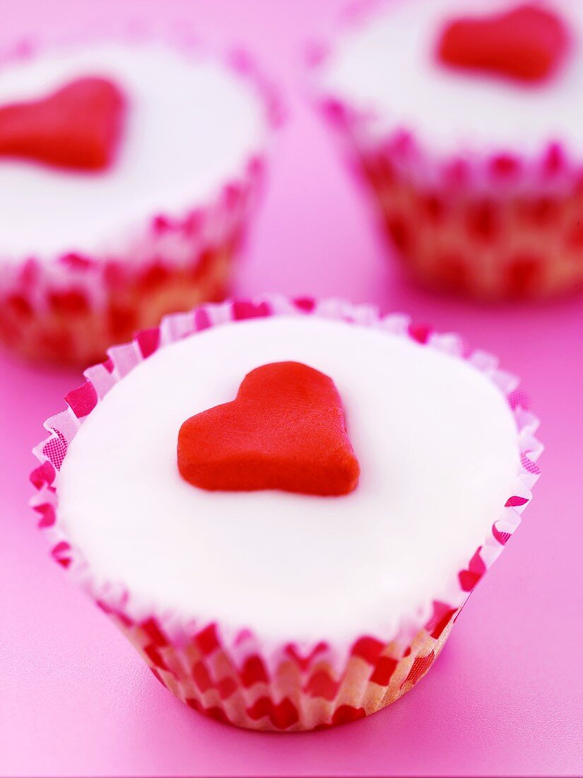 Three cupcakes decorated with marzipan hearts