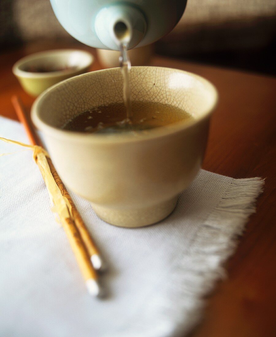 Pouring chai tea into a tea bowl