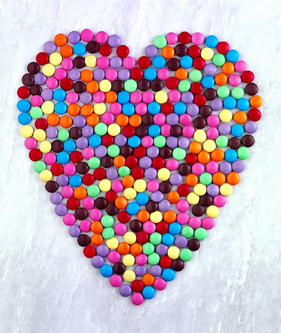 Coloured chocolate beans forming heart