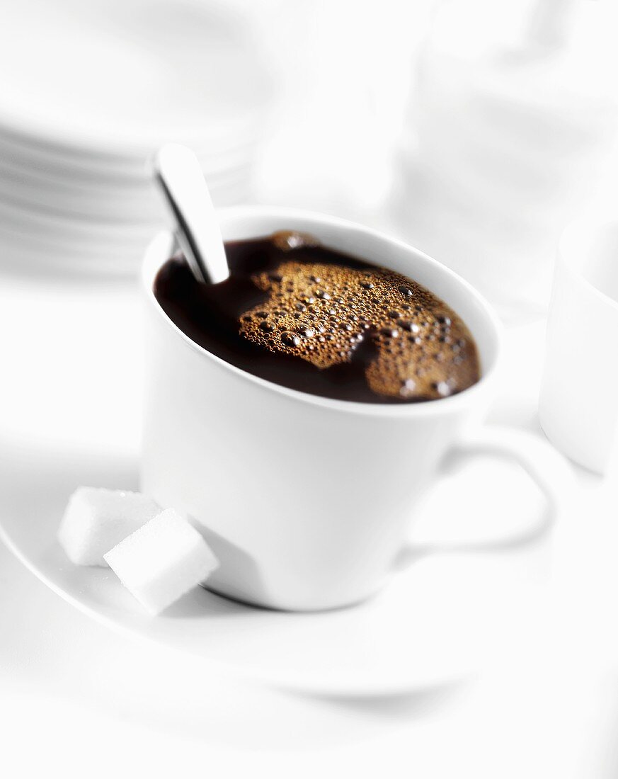 Eine Tasse schwarzer Kaffee mit Würfelzucker