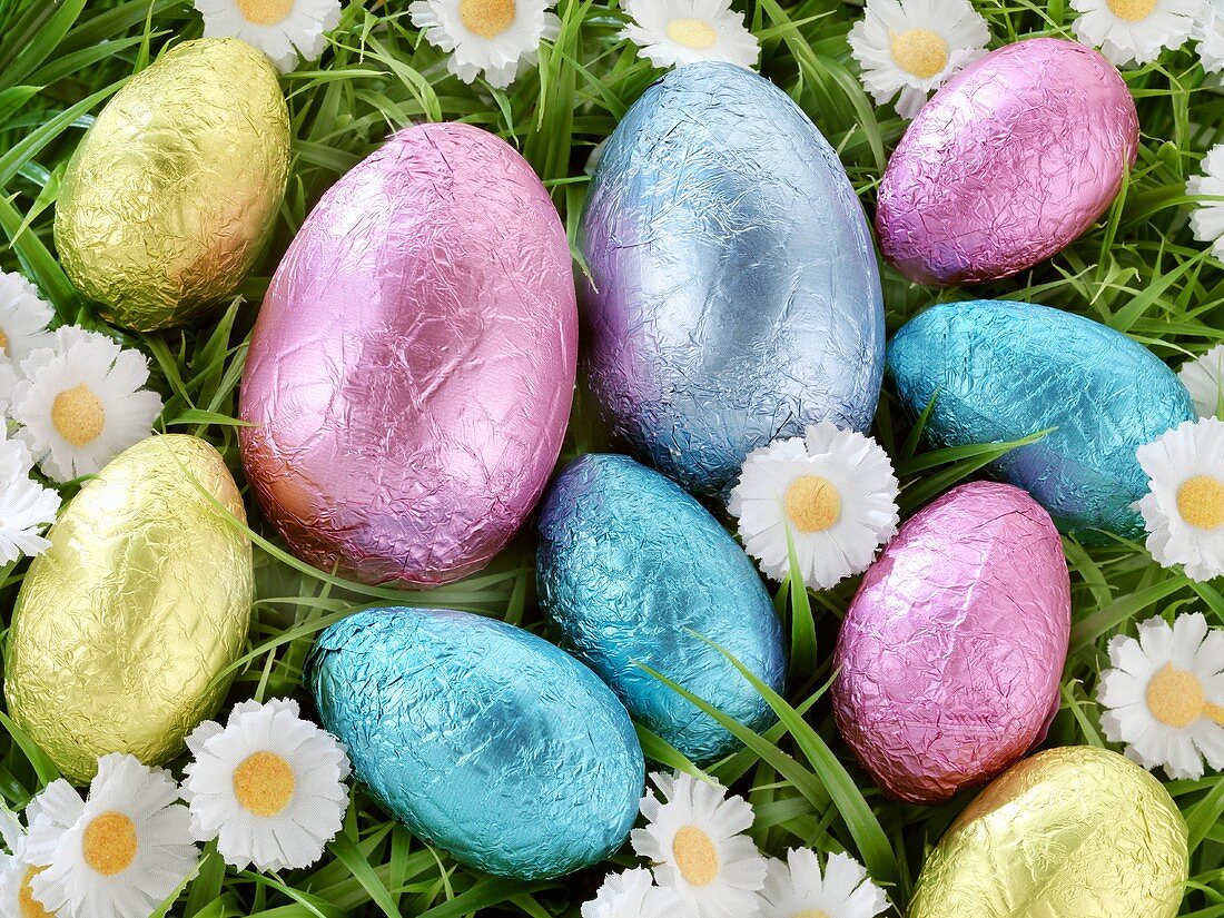Chocolate Easter eggs in coloured foil in grass