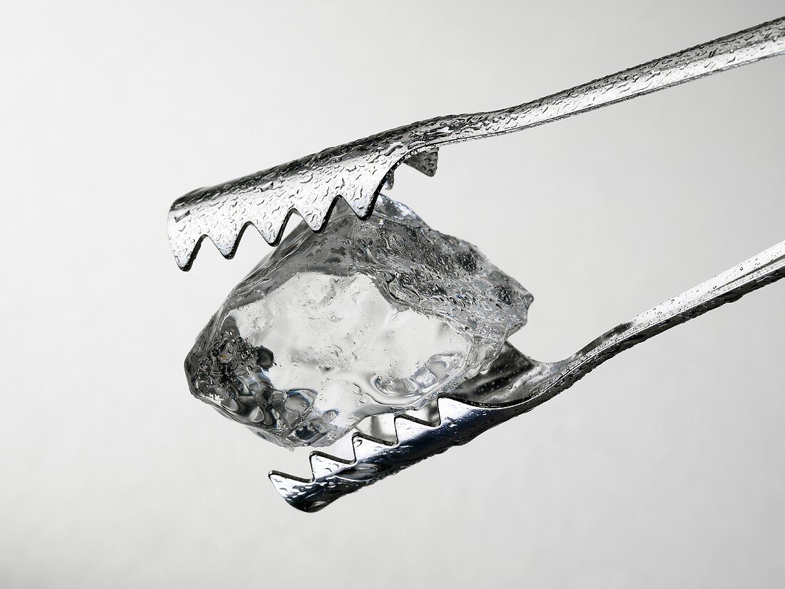 Tongs holding an ice cube