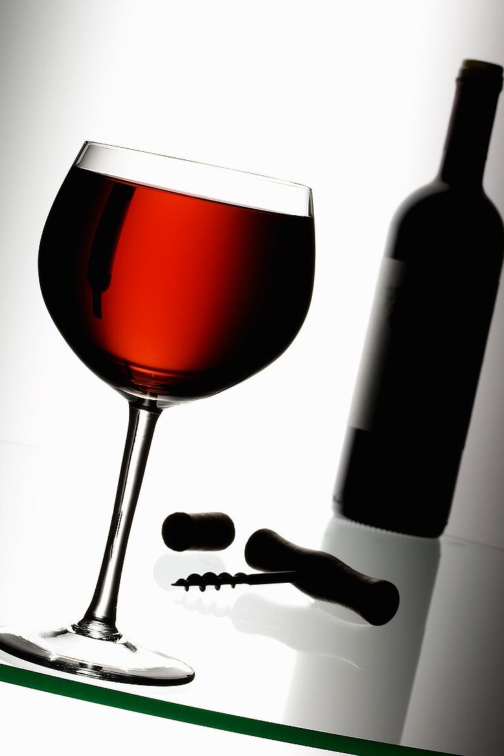 Glas Rotwein, Korkenzieher, Korken und Weinflasche
