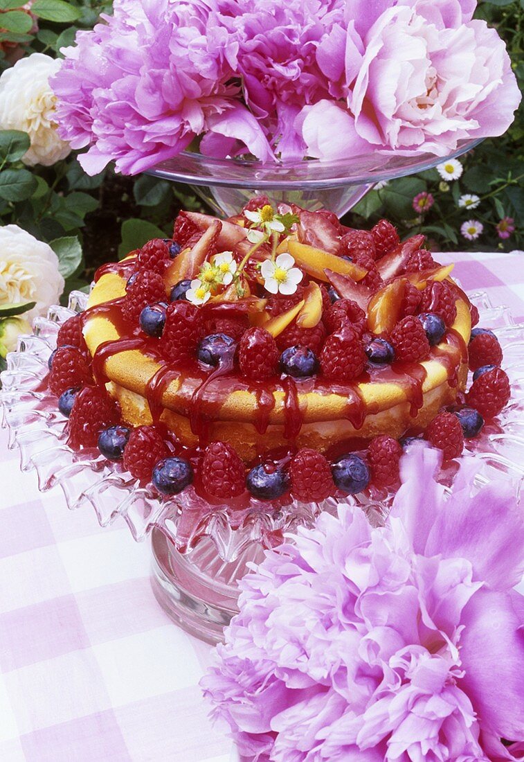 Summer berry torte and peonies on garden table