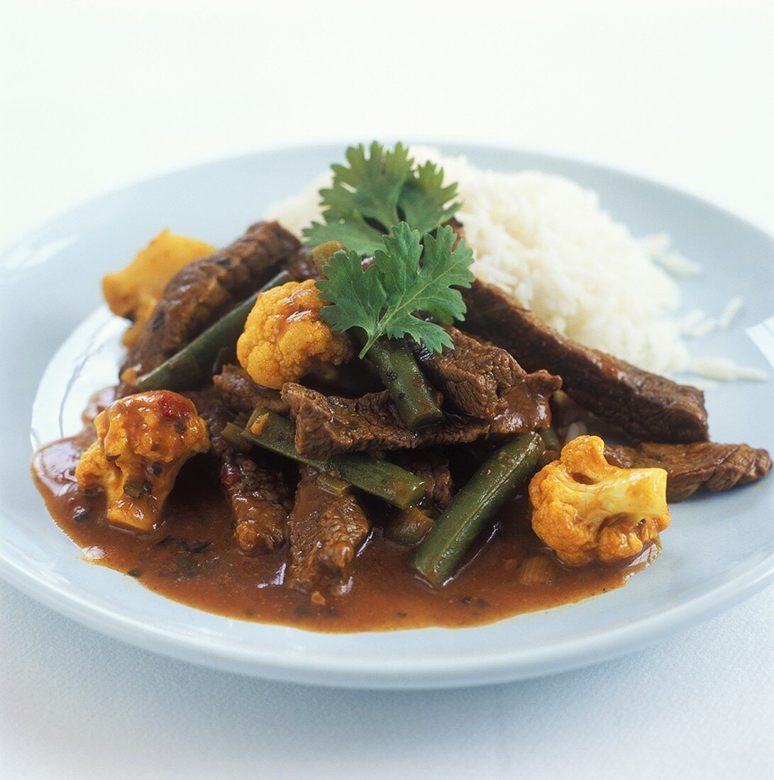 Beef curry with cauliflower, beans and rice