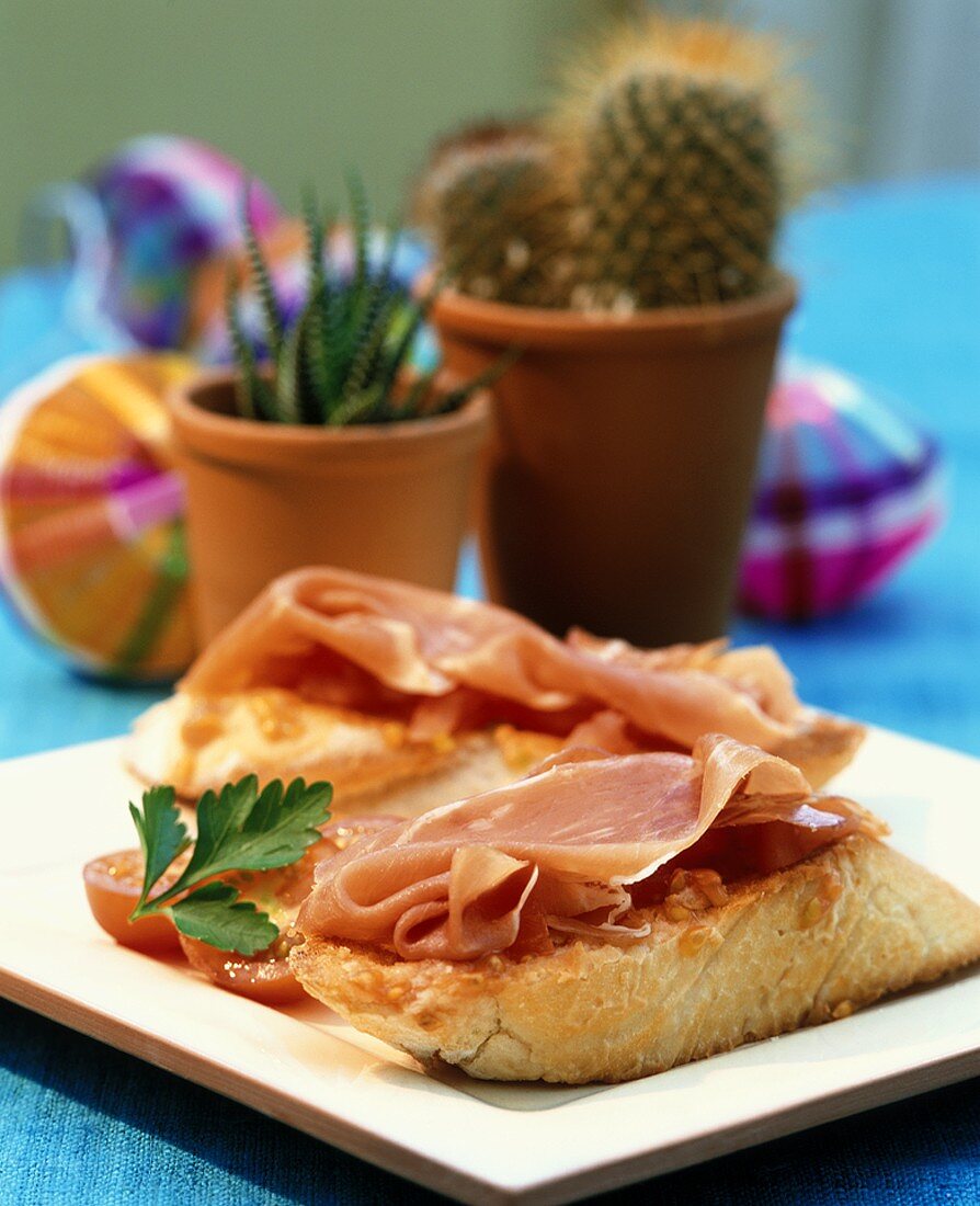 Toasted bread topped with tomatoes and Serrano ham