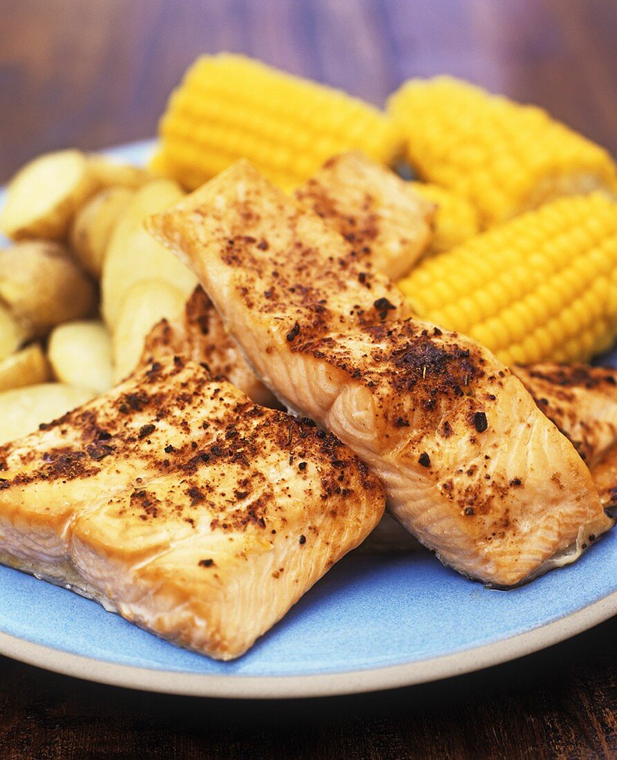 Cajun salmon with corn on the cob and potatoes