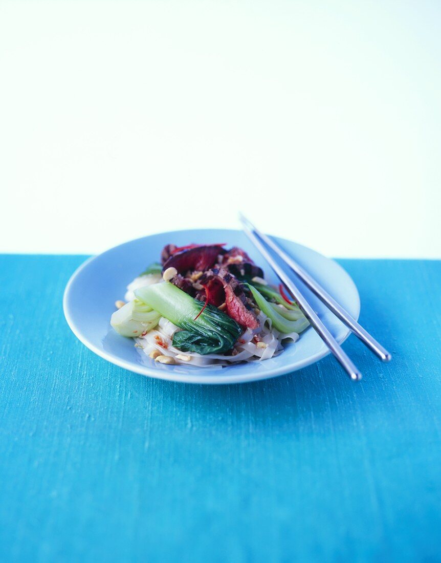 Warm rice noodle salad with beef, pak choi and peanuts
