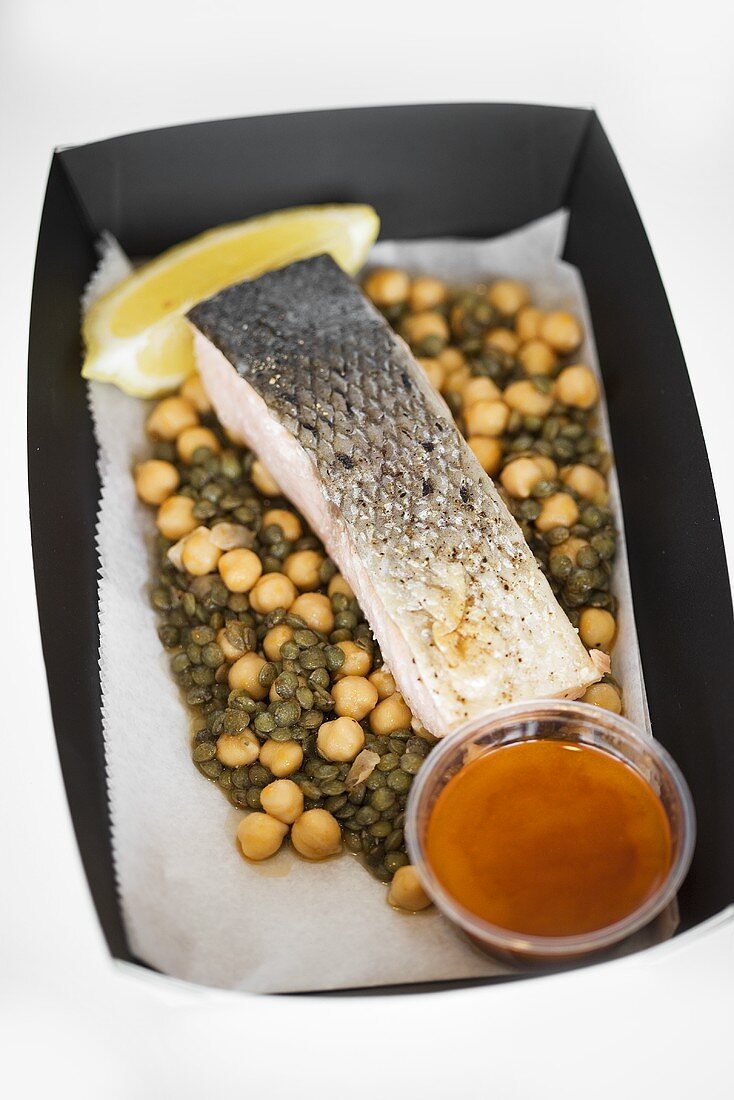 Salmon on chick-peas and lentils in cardboard container