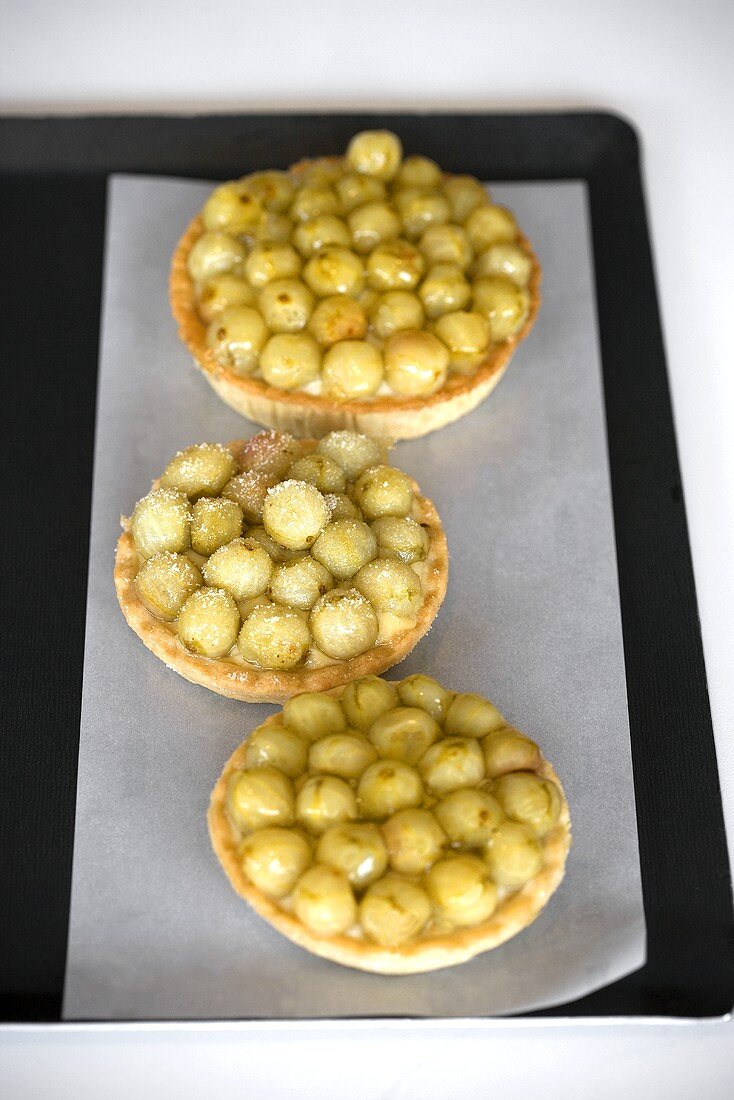 Three gooseberry tarts on baking tray