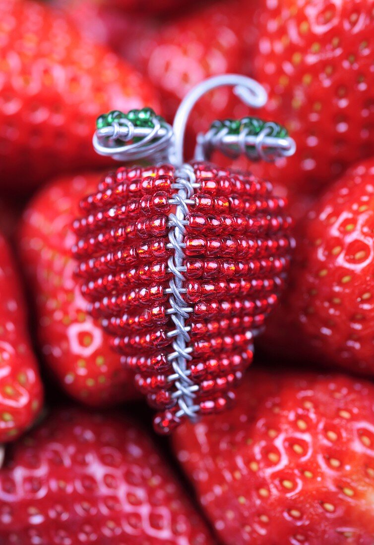 Deko-Erdbeere auf frischen Erdbeeren