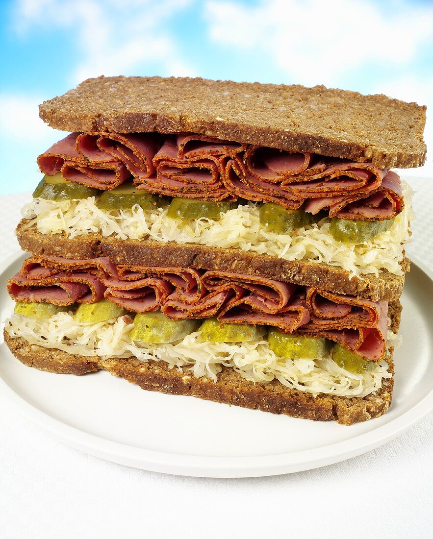 Double-decker pastrami, sauerkraut and gherkin sandwich