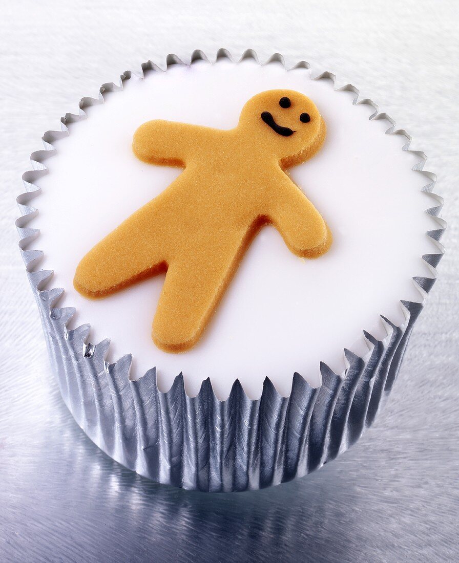 Cupcake with white icing and tiny gingerbread man