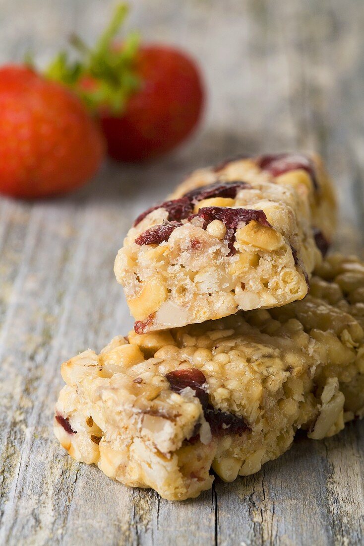 Muesli bars with red fruit on wooden background
