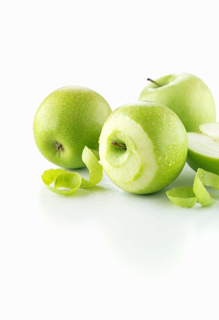 Green apples, one partly peeled