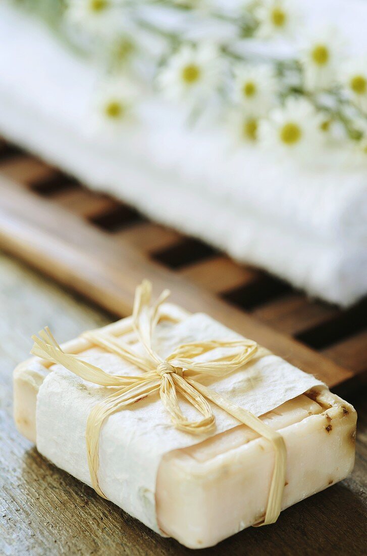 A bar of soap and towel with white asters
