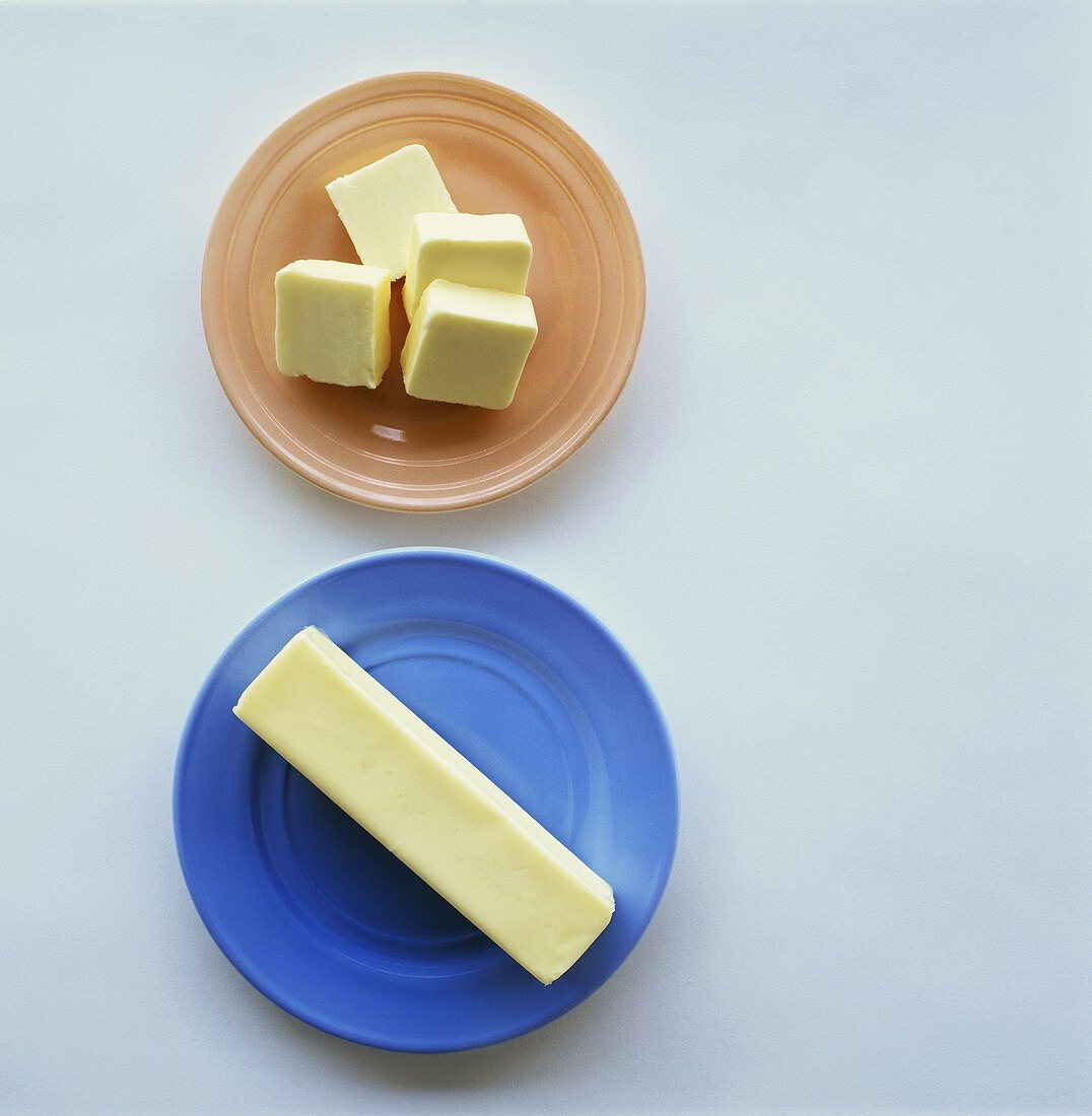 Pieces of butter on coloured plates