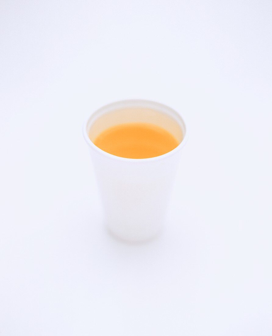 Orange juice in white beaker