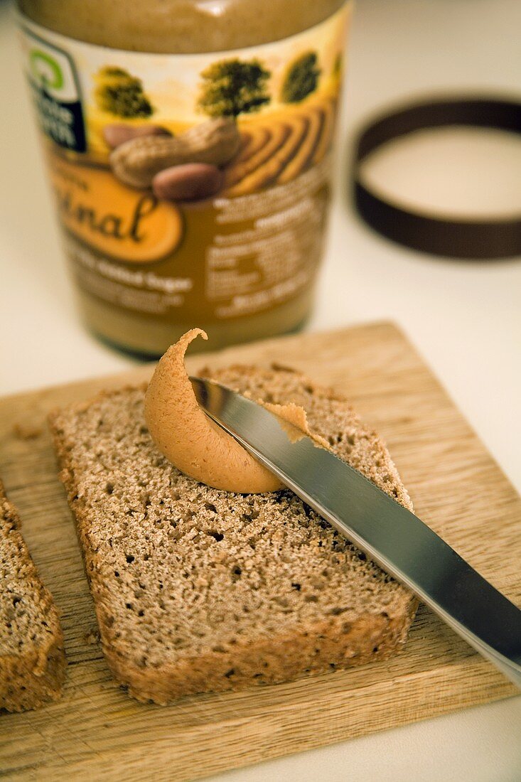 Spreading peanut butter on rye bread
