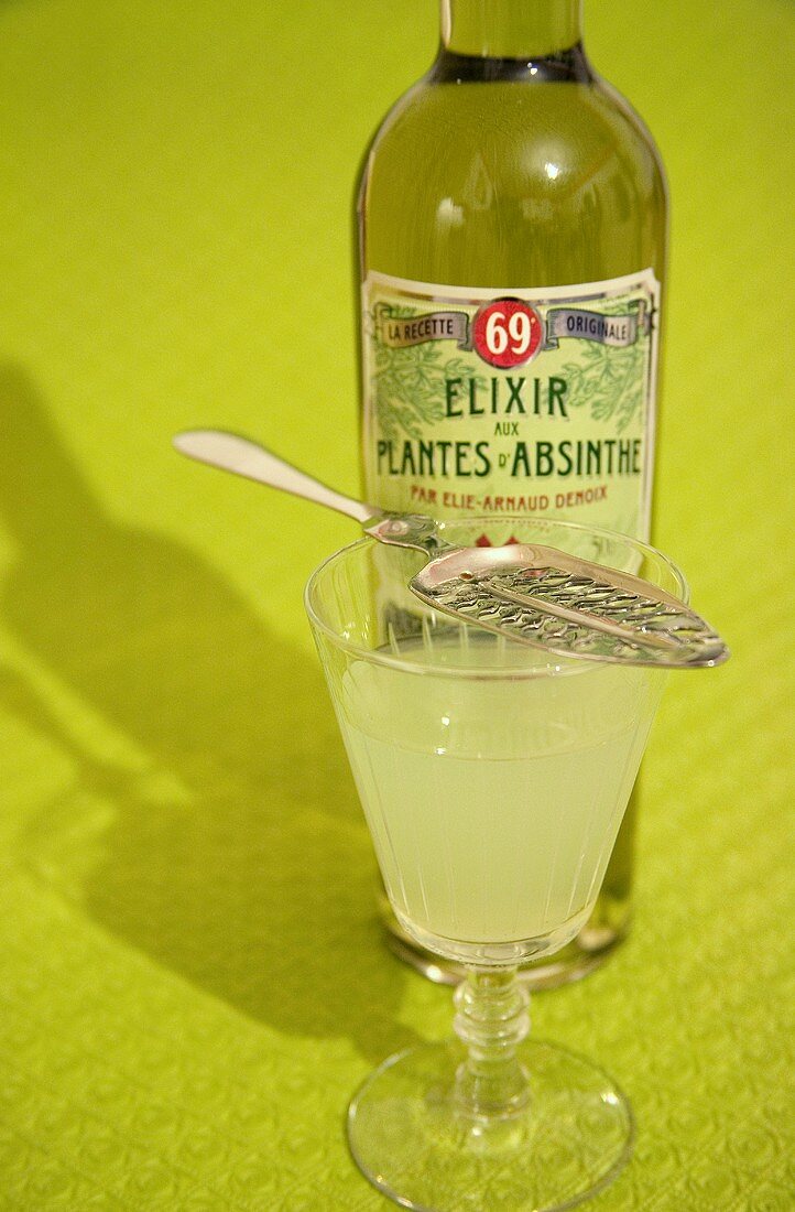 Absinthe with remains of sugar on a silver spoon