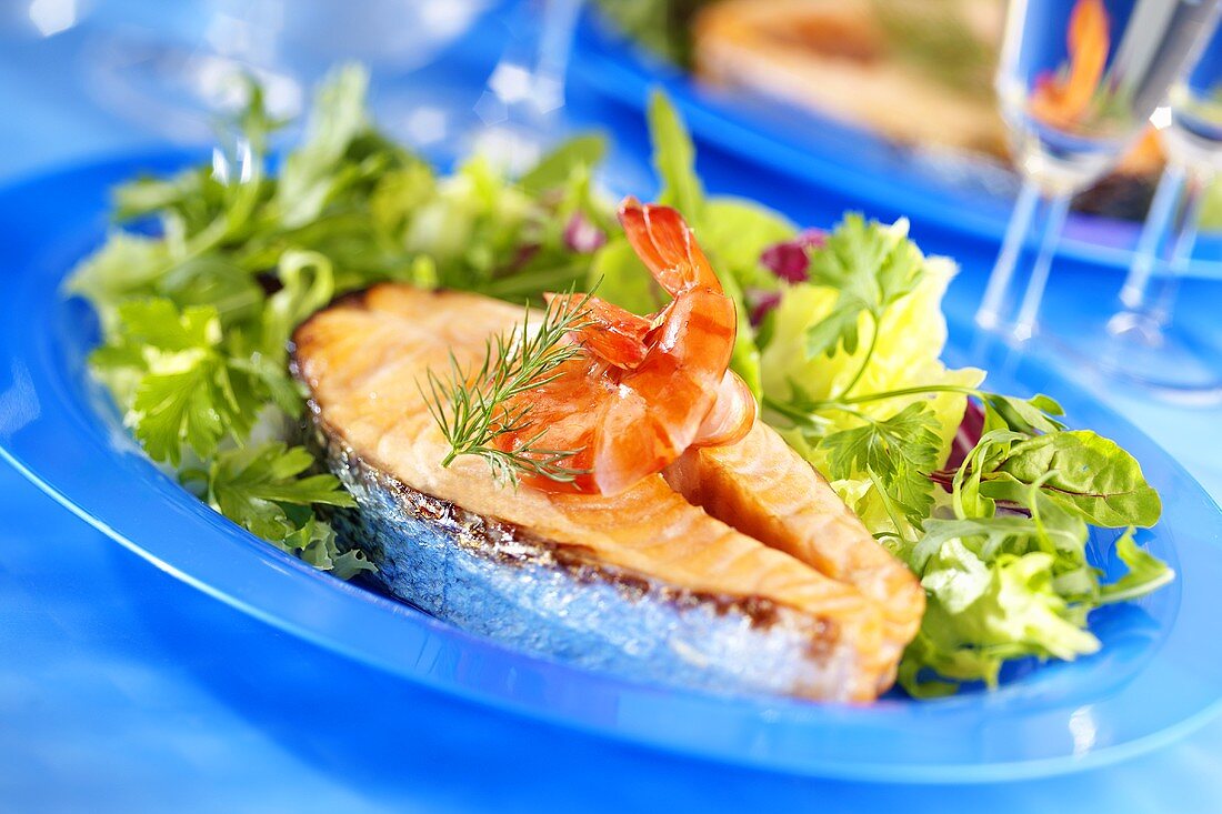 Fried salmon steak with mixed salad leaves and shrimps