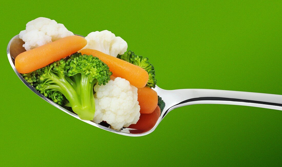 Cauliflower, broccoli and carrots on a spoon