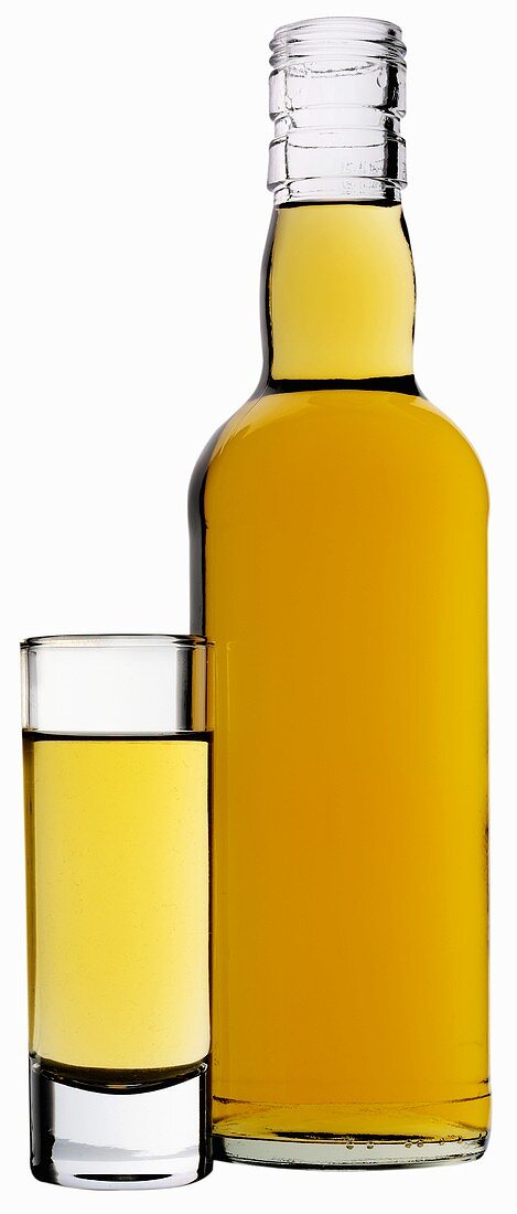 Brauner Rum in einem Glas und einer Flasche