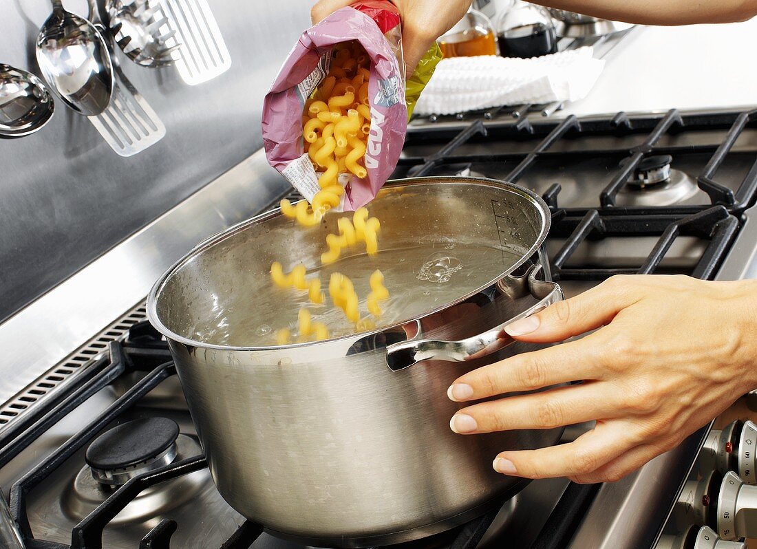 Putting pasta spirals into boiling water