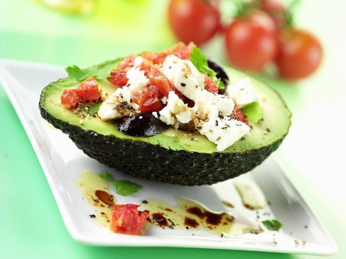 Mozzarella and tomato salad with black olives in avocado