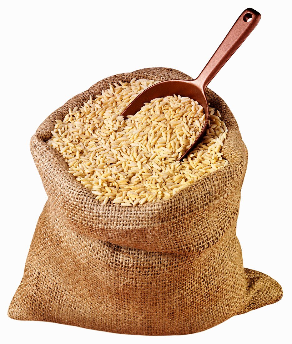 Kritharaki (Greek rice-shaped pasta) in jute sack with scoop
