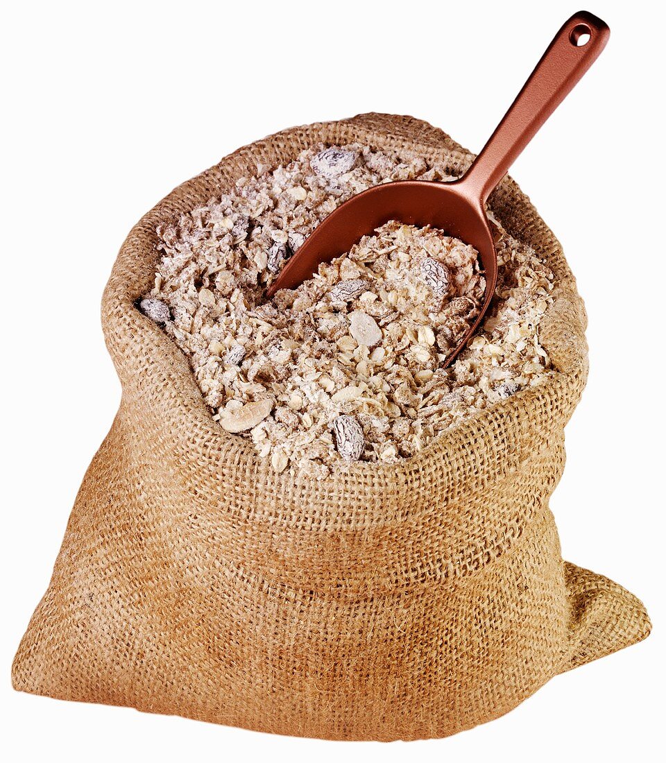 Muesli with rolled oats and nuts in jute sack with scoop