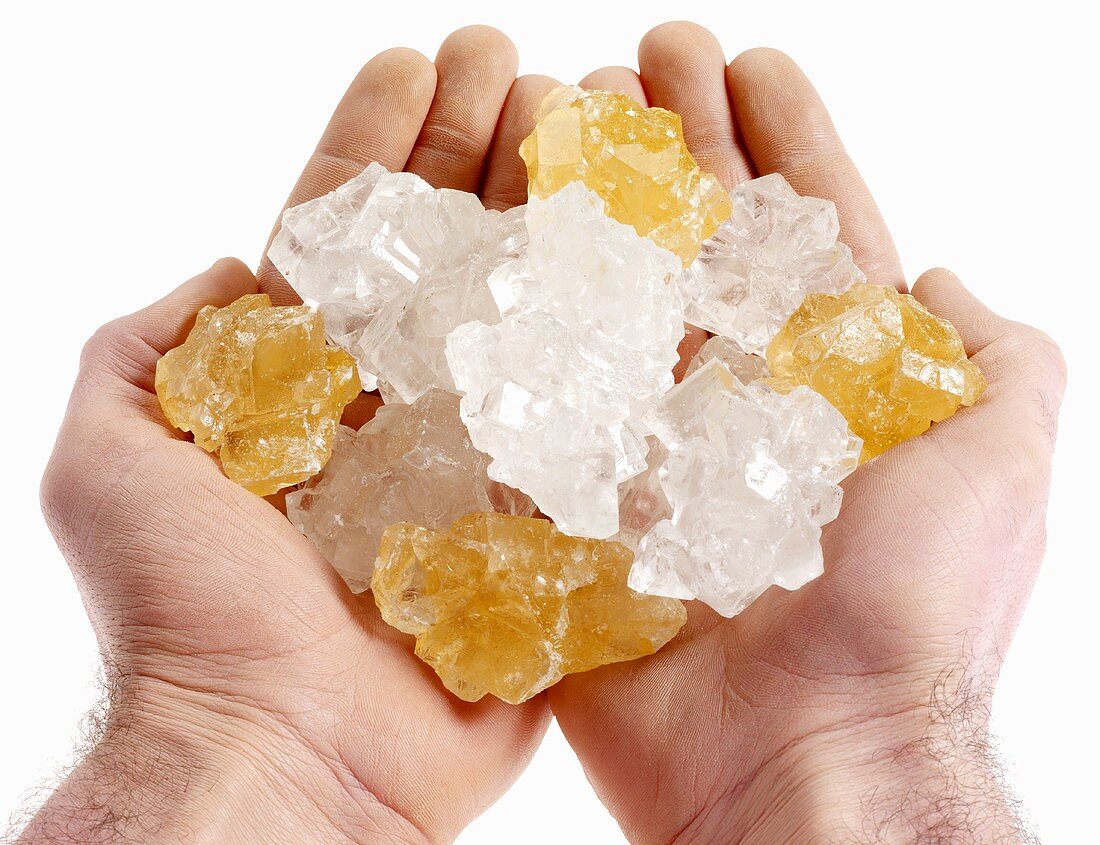 Hände halten Safran- und Kandis-Zucker-Kristalle
