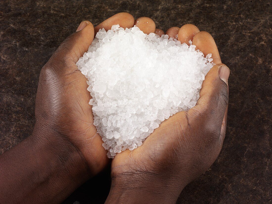 Hands holding coarse rock salt