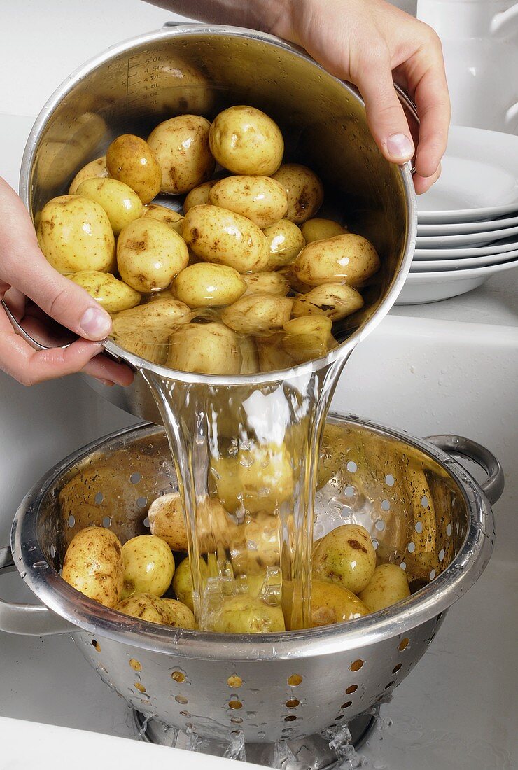 Kartoffeln aus dem Topf in ein Küchensieb schütten