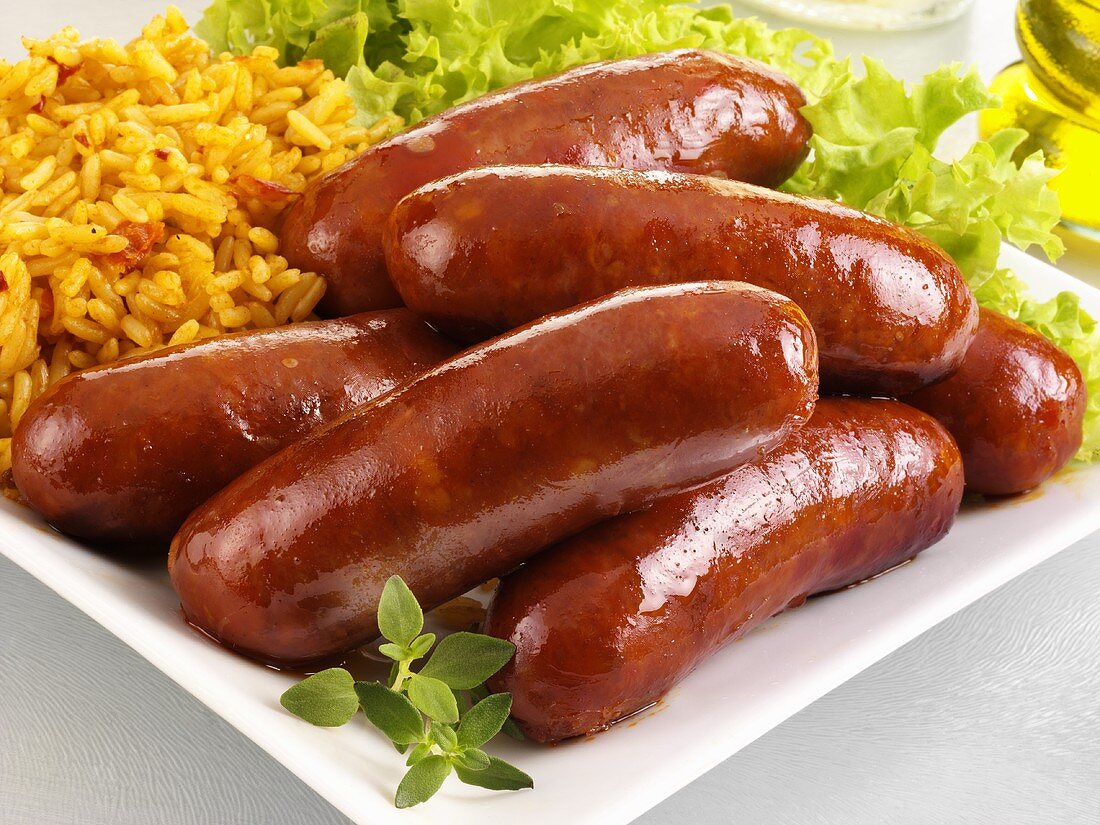 Fried chorizo sausages with rice and green salad
