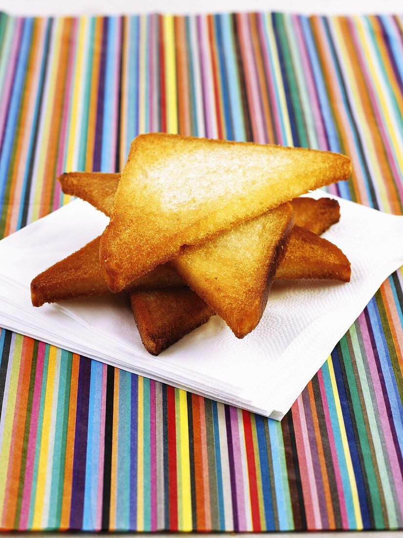 Four pieces of fried bread on kitchen towel