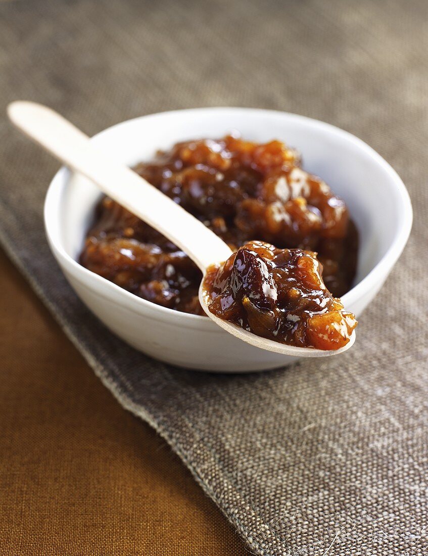 Tomaten-Zwiebel-Chutney in einer Schüssel mit Holzlöffel