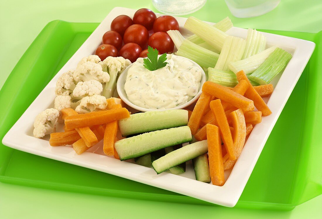 Raw vegetables on a platter with herb dip